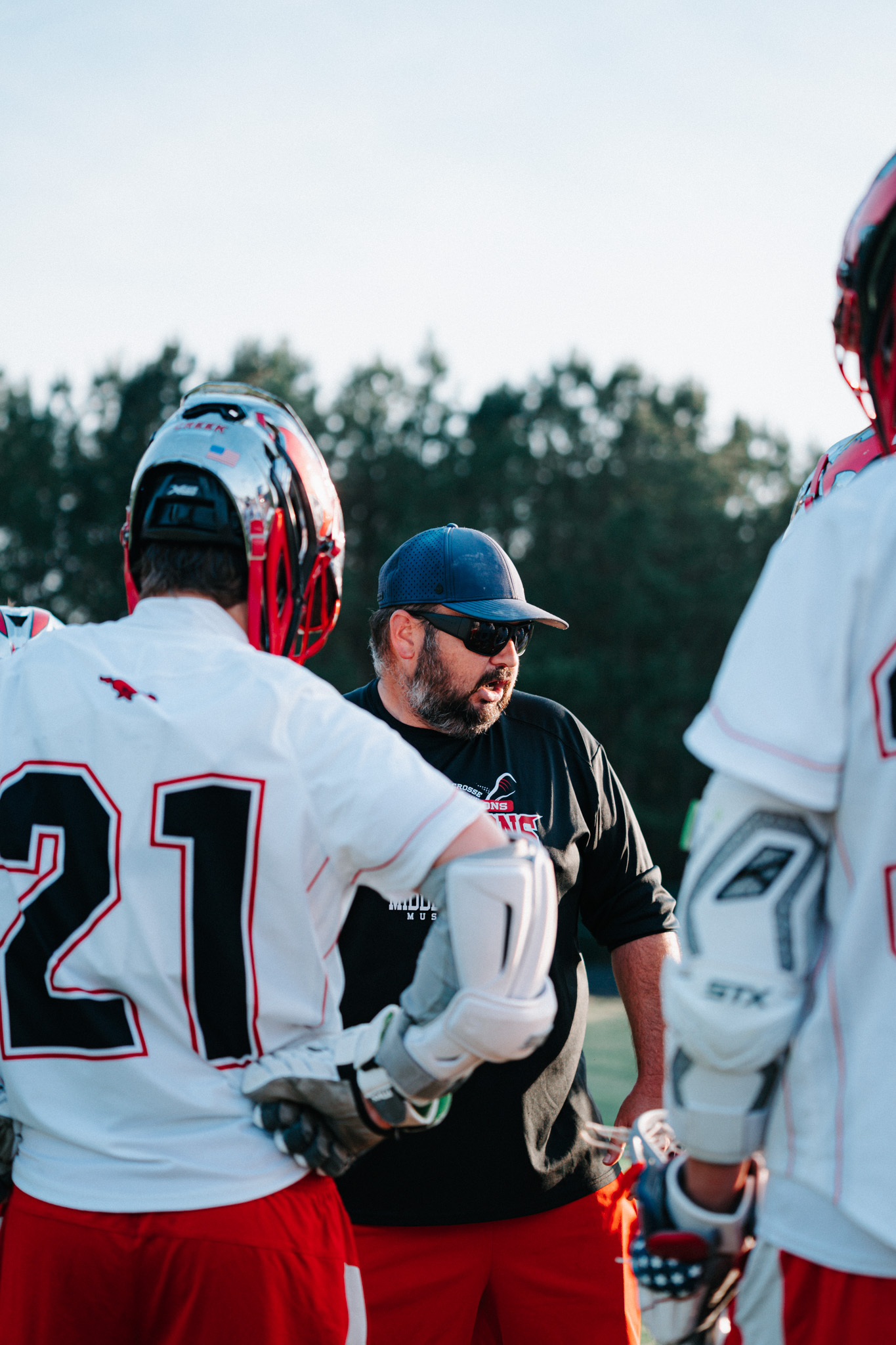 Head Coach Nick Holota speaking to Middle Creek players in a huddle